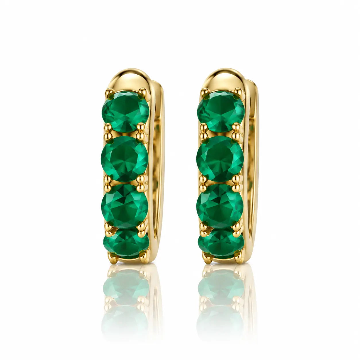 Gold hoop earrings with green gemstones on a white background