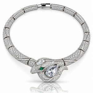A luxury diamond and silver-toned metal bracelet featuring a snake-head motif with a green emerald accent and pear-cut center stone, displayed on a clean white background with a soft reflection.