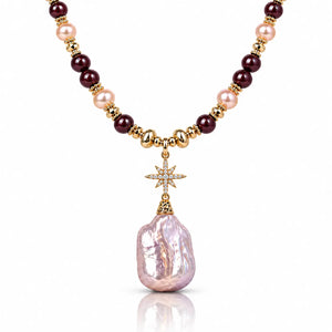 A luxury necklace featuring a large, irregular light pink baroque pearl pendant, suspended from a gold star charm. The chain is composed of alternating dark burgundy beads, light pink pearls, and polished gold spacer beads.