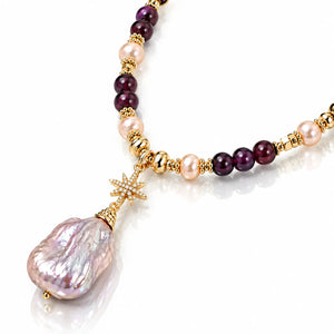 A luxury beaded necklace featuring a large baroque pearl pendant, pink freshwater pearls, deep purple beads, and gold spacer beads, accented with a gold star charm on a white background.