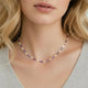 Woman wearing a delicate violet and pearl beaded necklace on bare neck