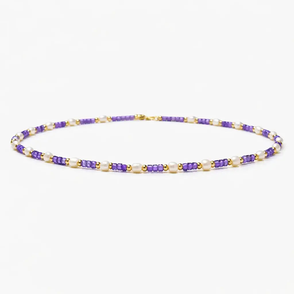 Violet pearl beaded necklace with gold accents on white background