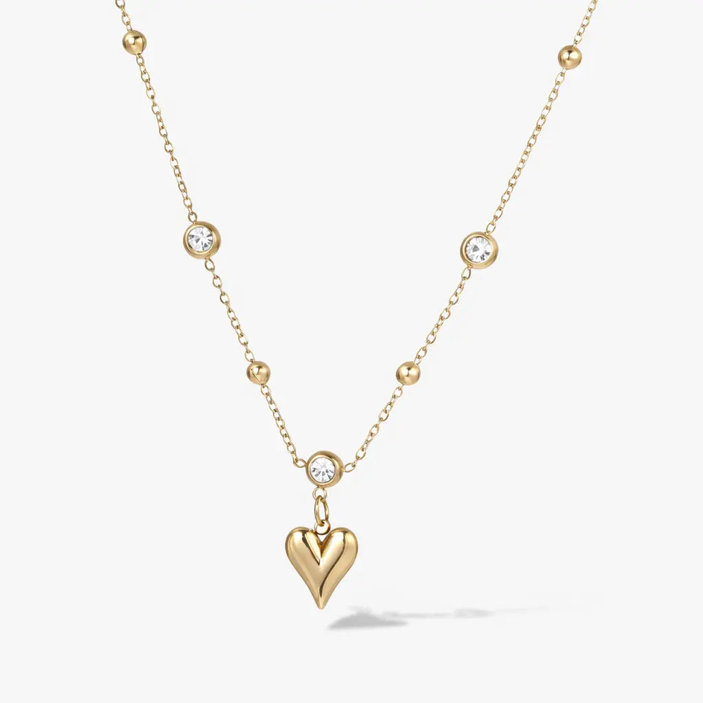 Gold plated necklace with heart pendant and round crystal accents on a delicate chain