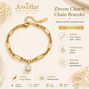 Jewellar Zircon Charm Chain Bracelet in 18K Gold Plated stainless steel, featuring a large paperclip-style chain and a dangling clear zircon stone. The image includes product specifications, weight, material, and care icons on a light cream background with decorative dried flowers.