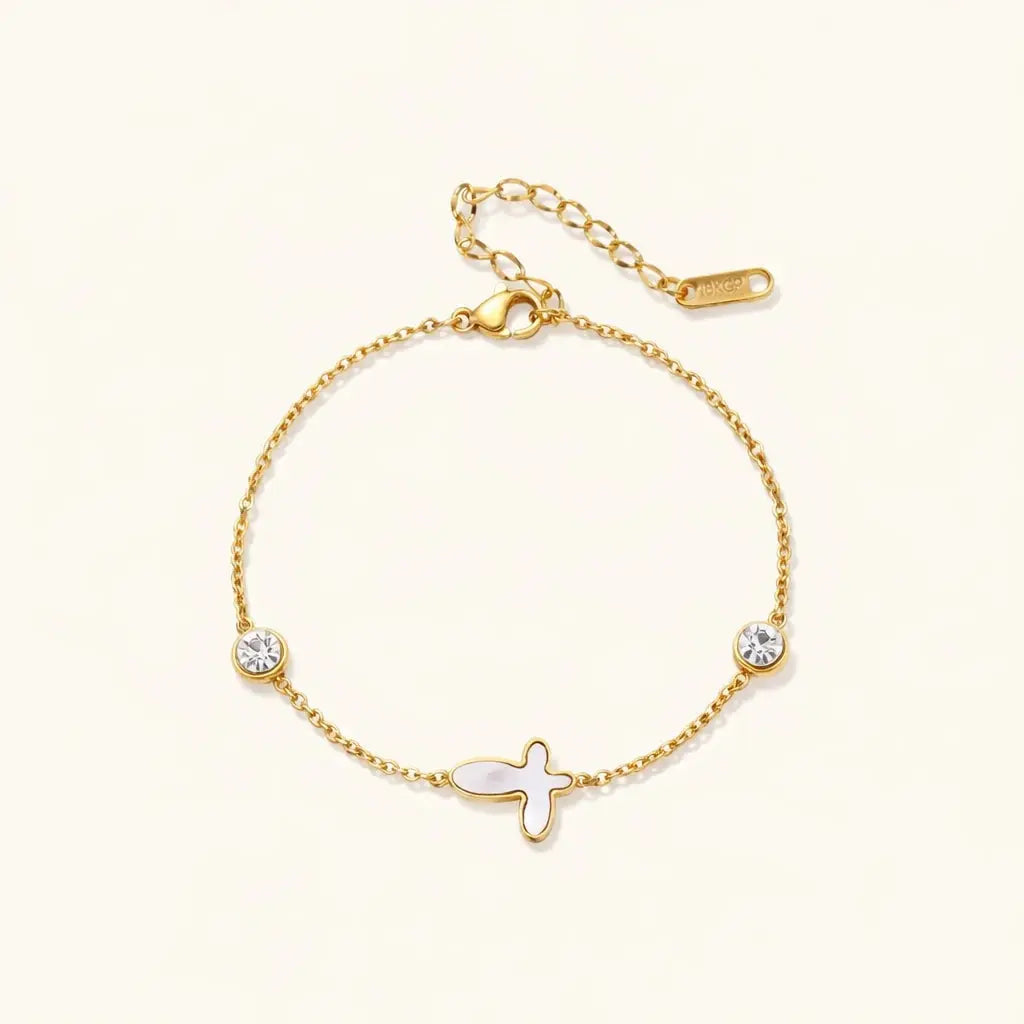 Gold bracelet with fish charm and crystals on a white background