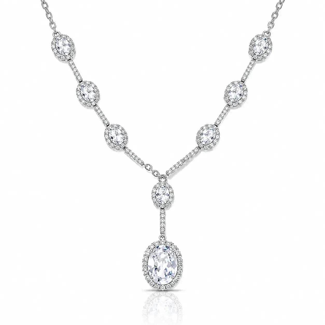 A silver-toned Y-shaped necklace featuring a series of oval and round diamond halo settings along the chain and a large oval diamond pendant, shown on a clean white background.
