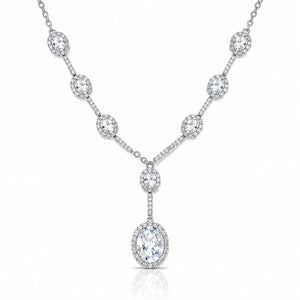 A silver-toned Y-shaped necklace featuring a series of oval and round diamond halo settings along the chain and a large oval diamond pendant, shown on a clean white background.