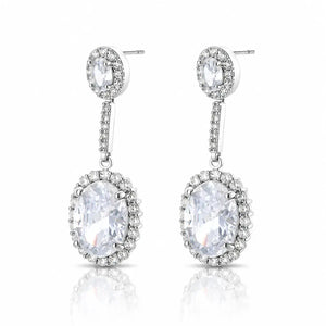 A pair of silver-tone drop earrings with oval clear gemstones surrounded by small accent stones, shown on a white background with a soft reflection below.