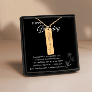Gold necklace with a pendant in a black gift box on a beige background