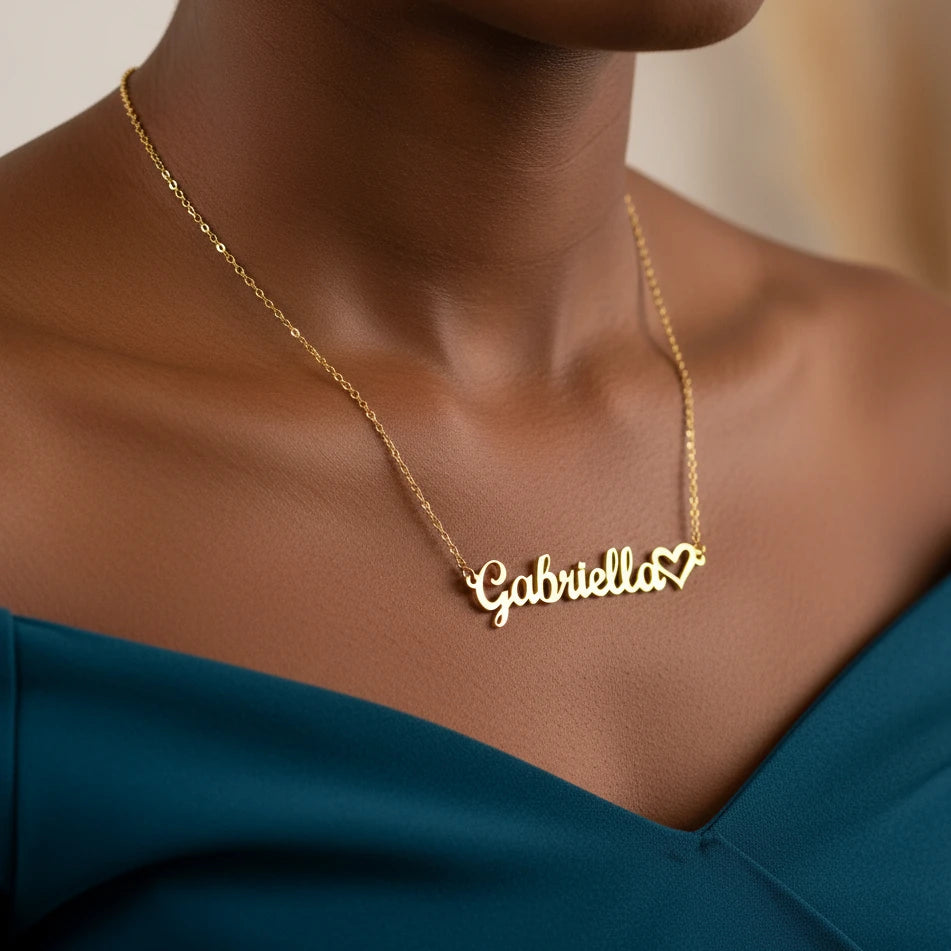 Gold necklace with 'Gabriella' pendant on a person wearing a blue top.