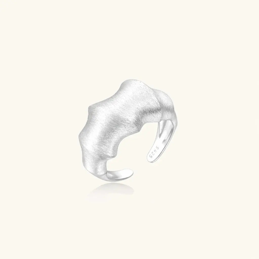 Silver ring with a textured design on a white background