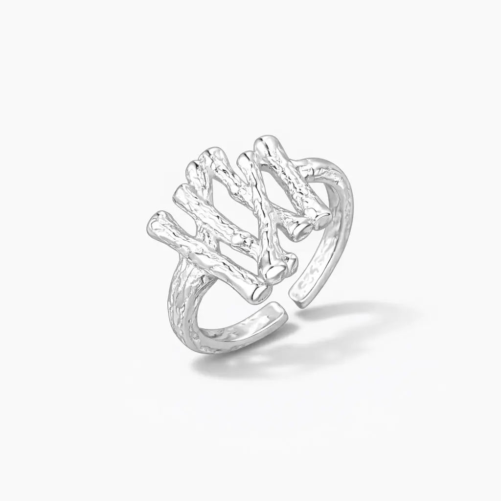 Textured silver branch design ring with open adjustable band on white background