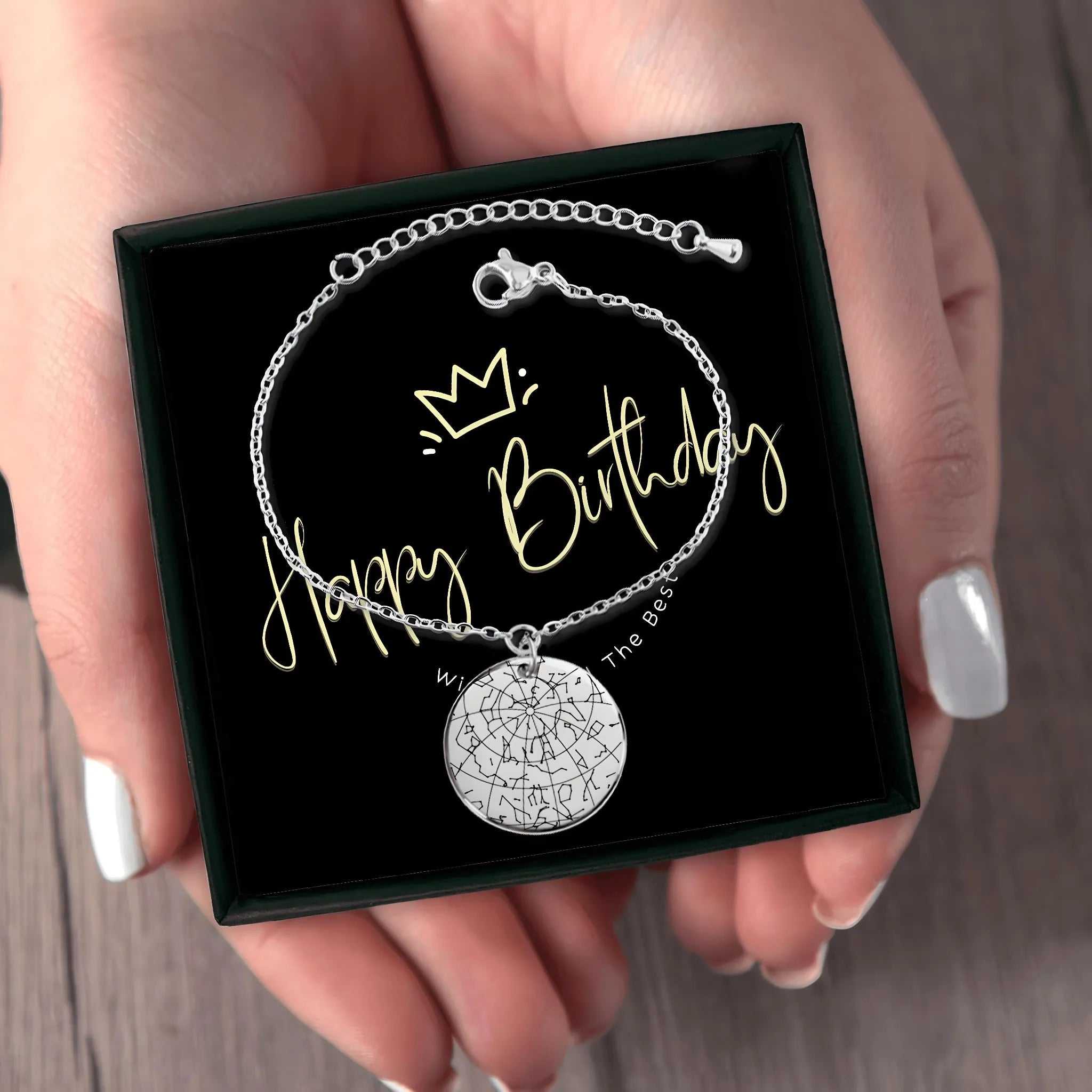 Silver star map bracelet in black gift box with Happy Birthday message held by hand, elegant jewelry